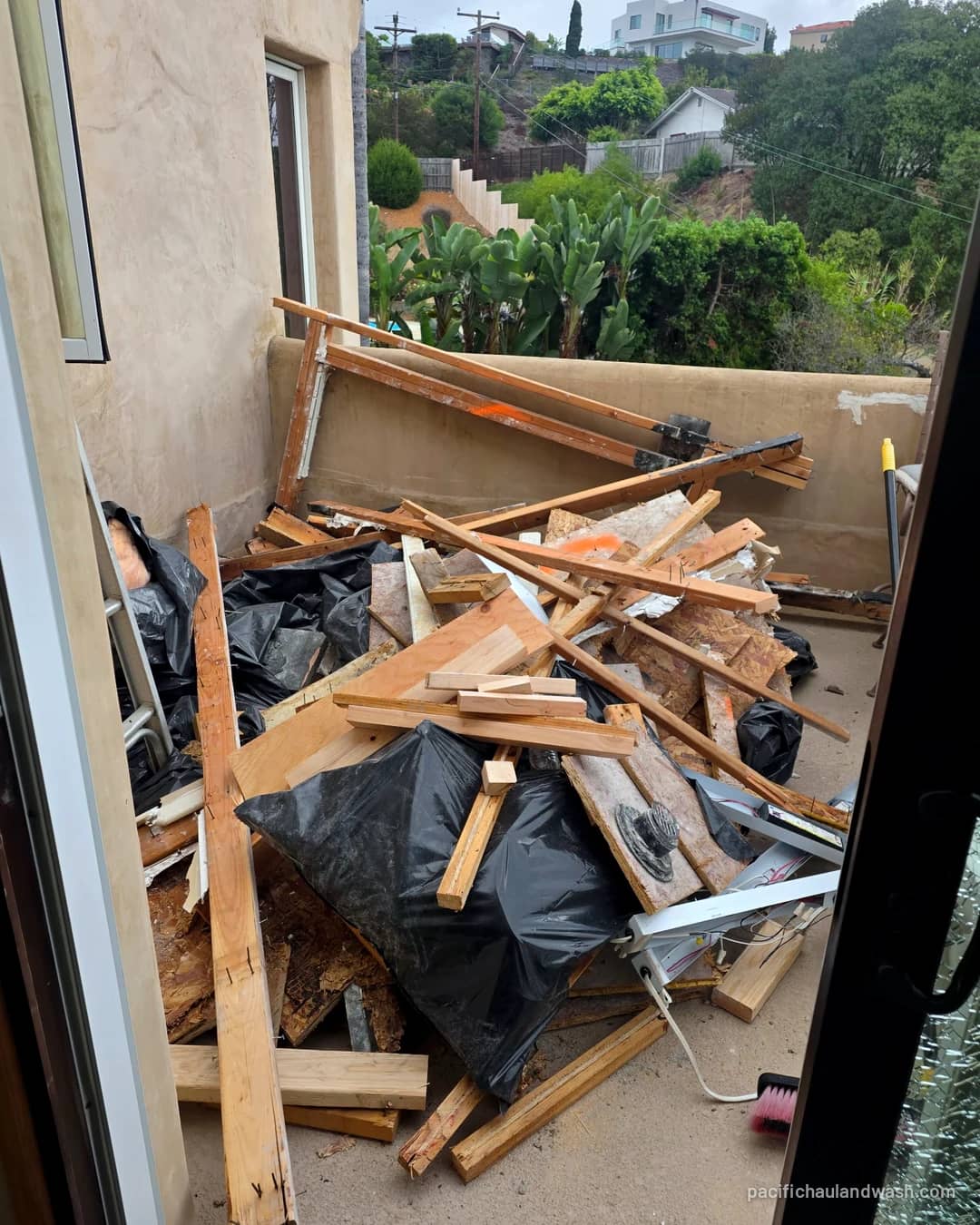Balcony piled with old lumber, boxes and household junk before a PHW haul-off