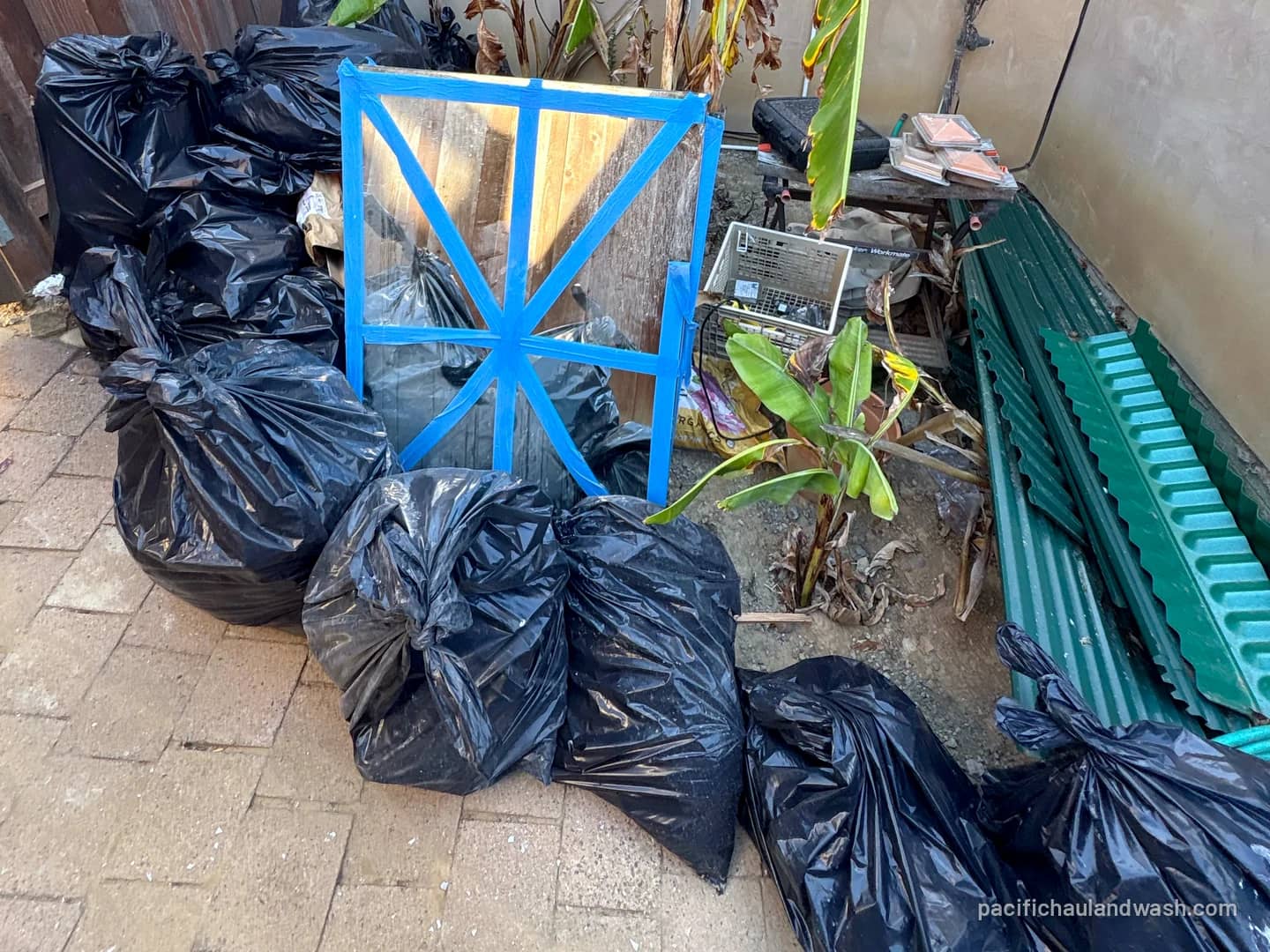 Bagged yard waste and debris stacked on a patio, ready for PHW to haul away