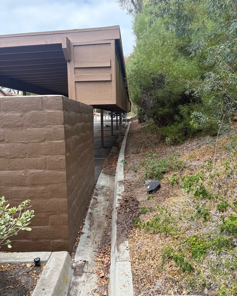 After: the hillside walkway beside the block wall with every mattress removed
