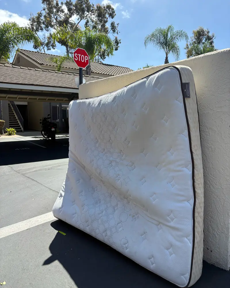 Before: an old white mattress propped against a wall outside a San Diego County home